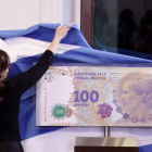 La presidenta argentina, Cristina Fernández de Kirchner, descubre una imagen del nuevo billete de 100 pesos, con la imagen de Eva Duarte de Perón, el miércoles, en Buenos Aires.