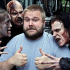 Robert Kirkman, rodeado de algunas de las criaturas protagonistas de The walking dead.