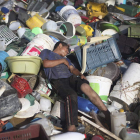 Un joven descansa sobre el vertedro de basura en el que recoge plásticos y metales.