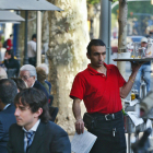 Un camarero trabajando en una terraza de un bar.