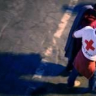 Un voluntario de Cruz Roja ayuda a uno de los inmigrantes  llegados al Puerto de los Cristianos