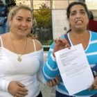 Dos mujeres de las famiias okupas muetran la citación judicial