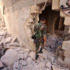 Un soldado del Ejército sirio inspecciona un edificio dañado en Alepo.