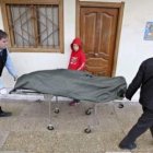 Dos hombres retiran el cuerpo de la mujer fallecida en Rentería