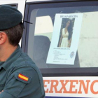 Un agente de la Guardia Civil, el 1 de septiembre, junto al cartel de búsqueda de Diana Quer, desaparecida en A Pobra do Caramiñal (A Coruña).