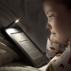 Imagen de archivo de una niña leyendo un libro en formato digital. FFE