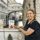 La escritora madrileña Megan Maxwell posa con uno de sus libros en un puente de Venecia