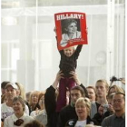 Una joven seguidora de Hillary muestra un cartel publicitario