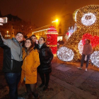 Un grupo de amigos se hace un selfie con el oso de luces en la plaza de San Marcelo.