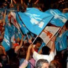 Seguidores del PP agitan las banderas del partido en el mitin de Rajoy
