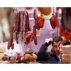 Una pareja realiza sus compras en un puesto del mercado del Conde donde se venden productos cárnicos leoneses.