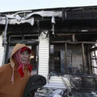Una mujer pasa junto a una casa destruida en la isla surcoreana de Yeonpyeong.