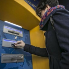 Una clienta bancaria utiliza su tarjeta en un cajero automático