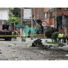 La policía examina los alrededores donde explotó un coche-bomba en Bogotá, junto a de Radio Caracol.