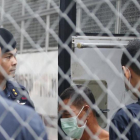 Agentes de policia tailandeses custodian la llegada de un sospechoso de trata de personas en el tribunal penal de Bangkok este miércoles