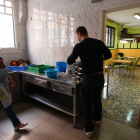 Dos voluntarios preparan la comida del comedor social.