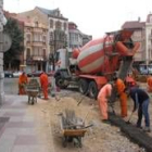 Unos obreros trabajan en los primeros metros de la calle de Manuel Diz, junto  a la plaza Mayor