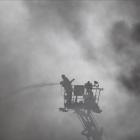 Un bombero trabaja en el lugar del incendio, una fábrica de embalajes de cuatro plantas.