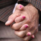 Dos ancianos se dan la mano en una romería en Garrafe de Torío .