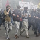 Estudiantes protestan entre gases lacrimógenos de la policía contra la reforma laboral.