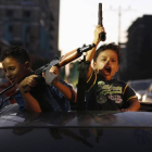 Niños palestinos con armas celebrando el alto el fuego en Gaza.