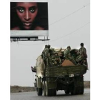 Soldados sirios que abandonan Líbano pasan ante un cartel publicitario