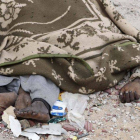 Un cadáver en descomposición, cubierto por una manta, en una calle de Sirte, el domingo.