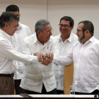 Raúl Castro sostiene las manos estrechadas del presidente de Colombia, Juan Manuel Santos, y del líder de las FARC, Rodrigo Londoño, alias 'Timochenko', este miércoles en La Habana.