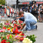 Un hombre deposita flores junto al lugar del ataque.