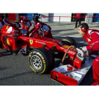 El piloto español Fernando Alonso al volante del Ferrari F2012 en boxes con sus mecánicos.