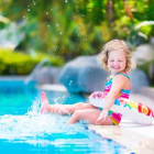 Una niña pequeña jugando en la piscina.