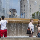 Unas personas se remojan en una fuente este verano en plena ola de calor