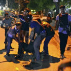 Un grupo de personas traslada a un herido en Dacca, anoche.