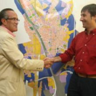 Cecilio Vallejo y Francisco Gutiérrez se saludan ante un plano de la ciudad de León.
