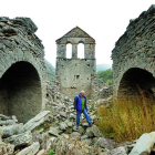 Albito Suárez entre las ruinas de la iglesia de Lagüelles, el pueblo en el que vivió hasta los ocho años y del que los vecinos salieron en barca.