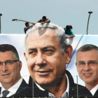 Un grupo de operarios trabaja en una valla publicitaria de propaganda electoral en la que aparece Netanyahu con candidatos de su partido, el Likud, en Jerusalén.