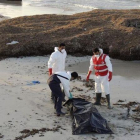 Miembros de la Media Luna Roja libia retiran el cadáver de un inmigrante fallecido en su intento de llegar a territorio europeo.