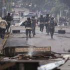 Agentes antidisturbios persiguen a manifestantes, este jueves en Chacao, al este de Caracas.