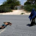 Una somalí camina y deja atrás el cadáver de un etíope