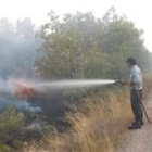 Imagen de archivo de un operario que intenta apagar unas llamas del incendio de Lucillo