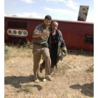 Un bombero ayuda a unos de los heridos del accidente de autobús