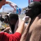 Un guardia civil da de beber a uno de los 37 inmigrantes que llegaron en pateras a Fuerteventura
