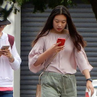 Dos chicas pasean por la calle sin hablarse y absortas en sus teléfonos móviles