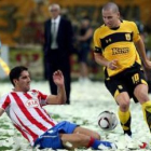 El rojiblanco Raúl García trata de arrebatarle el esférico al jugador del Aris Sergio Koke.