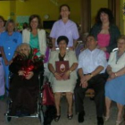 Zósima García, rodeada de familiares y cuidadoras, sostiene las flores que recibió.