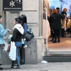 Un grupo de jóvenes charla después de ir de compras en el primer día de rebajas de invierno en Barcelona.