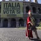 Un hombre vestido de centurión pasa frente al Coliseo romano.