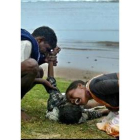 Unos padres hindúes lloran sobre el cadáver de su hijo en una playa del estado de Tamil