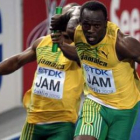 Usain Bolt  recibe el testigo de su compañero Michael Frater durante la final de 4x100 metros.