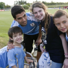 Luis Suárez posa con una jóvenes aficionados tras su primer entrenamiento con la selección uruguaya.